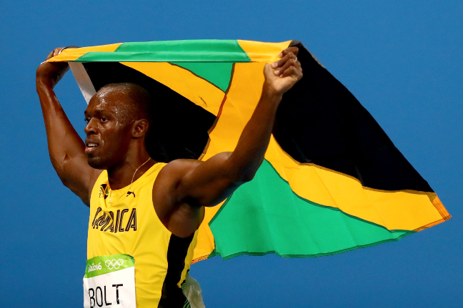 Bolt e a bandeira da Jamaica após a vitória nos 200m 